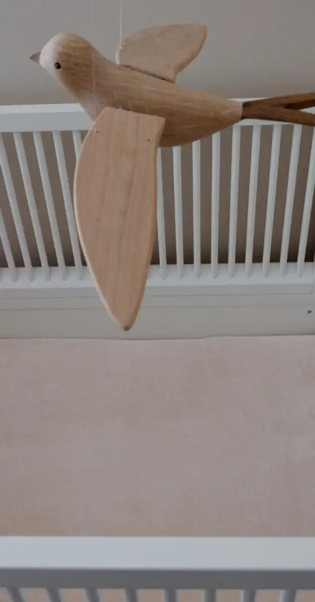 Houten vogelschilderij met uitgespreide vleugels.