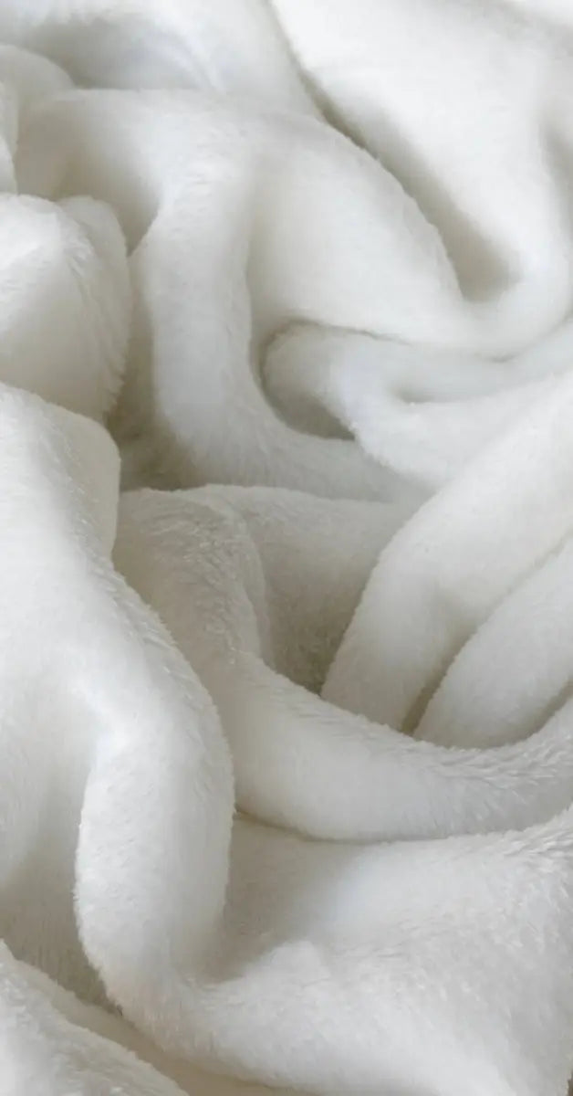 Close-up foto van een ivoor kleurig plaid waarbij de fijne textuur , zachte glans en zachtheid van de stof duidelijk zichtbaar zijn. De warme kleur en het delicate weefpatroon dragen bij aan de luxe uitstraling van de plaid.
foto: stof plaid ivoor