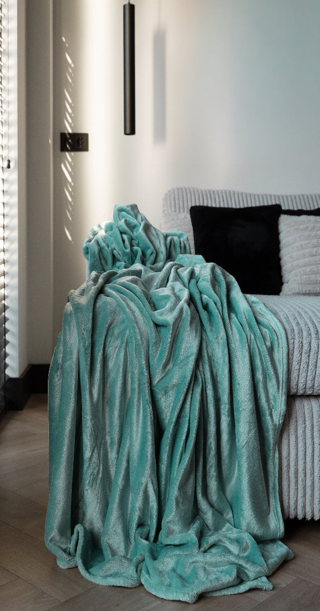 Een plaid in een mooie aqua groene kleur van 150x200 cm en 200x220 cm is mooi gedrapeerd over een bank in een gezellige kamer. De plaid voegt een warme en uitnodigende sfeer toe aan de ruimte, met zachte texturen en een stijlvolle kleur die perfect past bij het interieur.
foto: plaid aqua groen