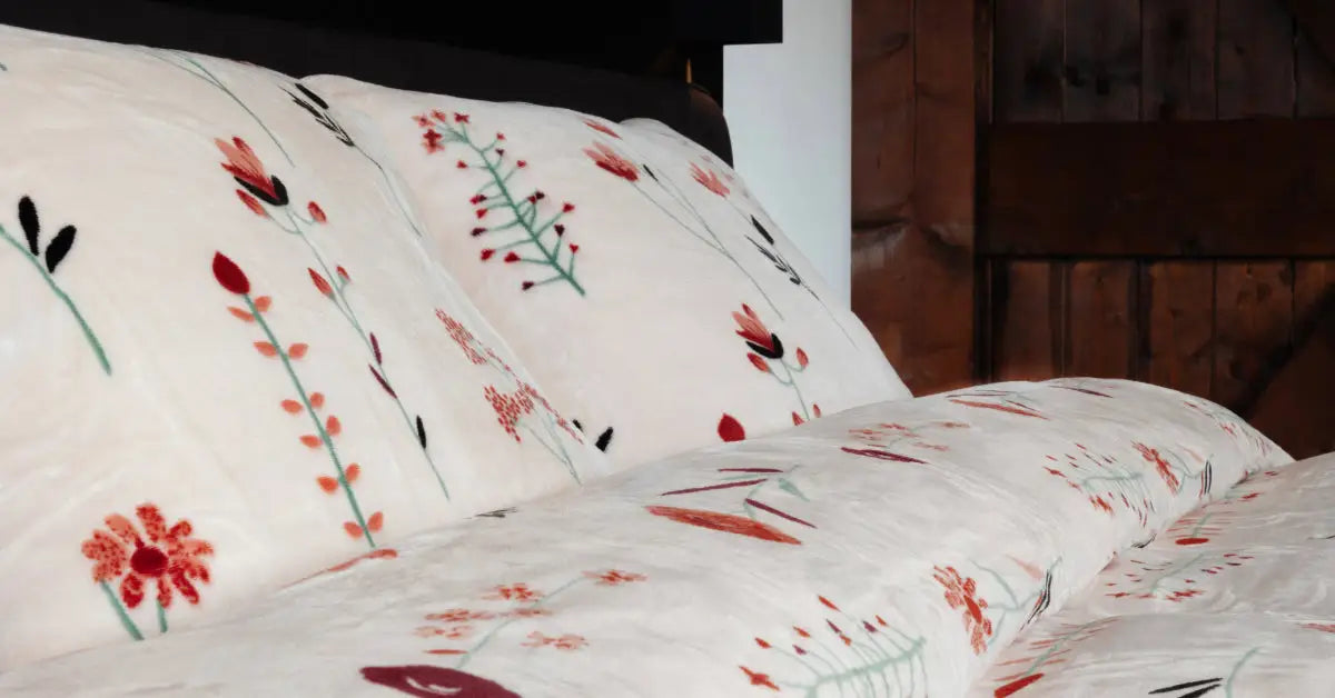 Een luxe tweepersoons velvet dekbedovertrek met een patroon van rode klaprozen, elegant gedrapeerd op een opgemaakt bed in een sfeervolle slaapkamer. foto: dekbedovertrek klaproos.