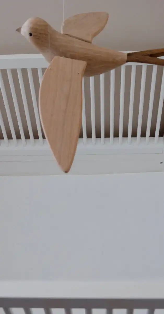 Houten vogelsculptuur met uitgespreide vleugels.