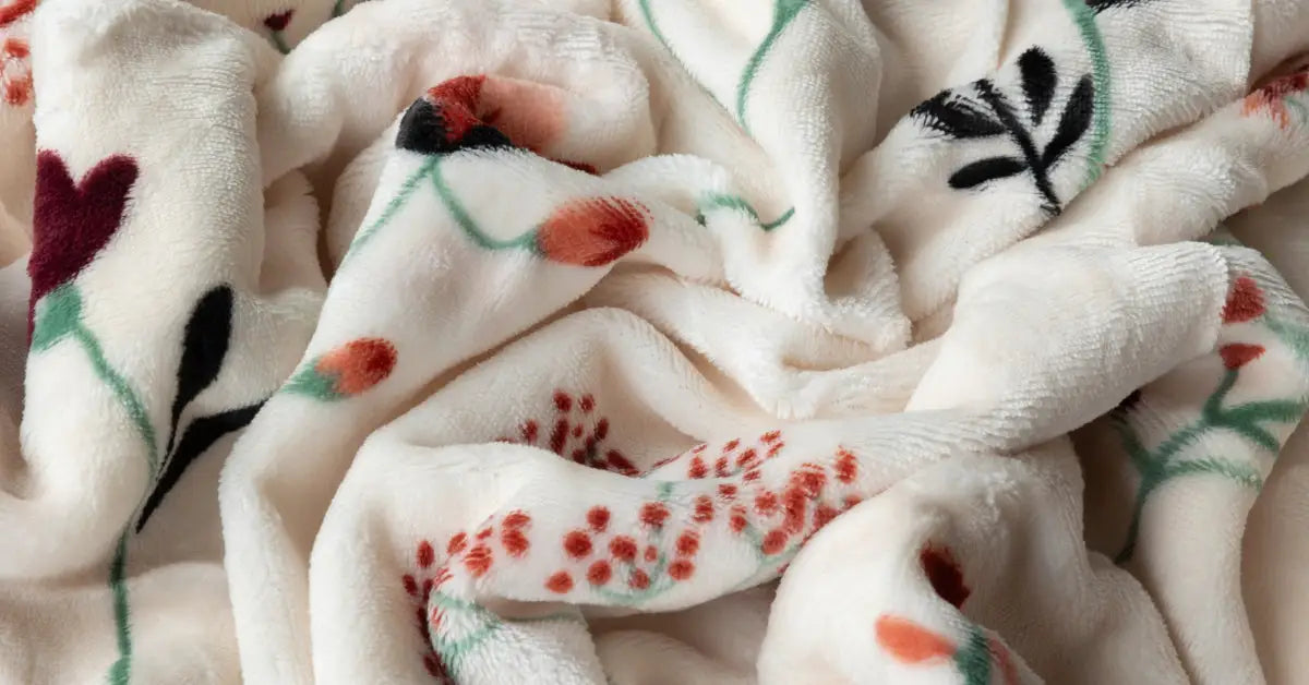 Close-up van de fluweelachtige stof van een dekbedovertrek met een kleurrijk patroon van klaprozen, ontworpen voor kinderen. De zachte textuur van het velvet materiaal is duidelijk zichtbaar, met levendige rode en groene tinten van de bloemen die een speelse en uitnodigende uitstraling geven. foto: kaproos dekbedovertrek eenpersoons stof.