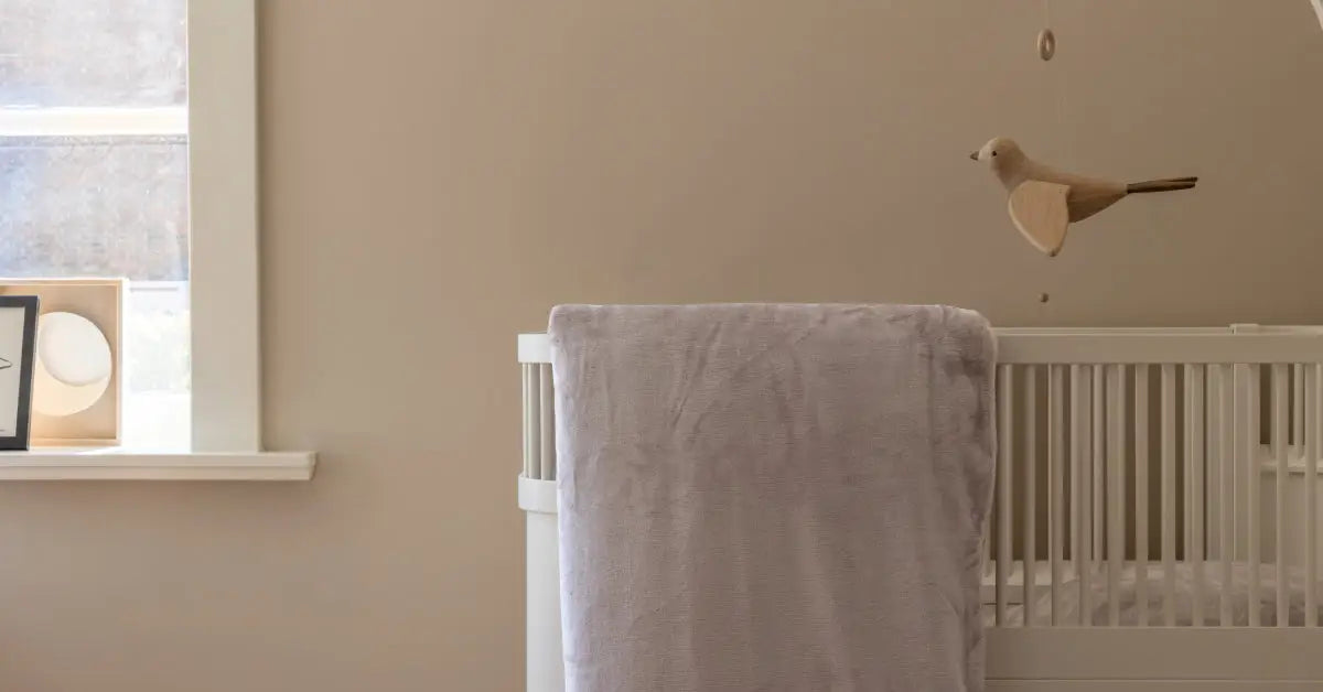 Close-up van een taupe velvet dekbedovertrek dat hangend over een ledikantje in een babykamer. Het zachte materiaal glanst lichtjes in het warme licht van de kamer, terwijl de schaduw van het dekbedovertrek de structuur van de stof accentueert.
foto: ledikant dekbedovertrek taupe 