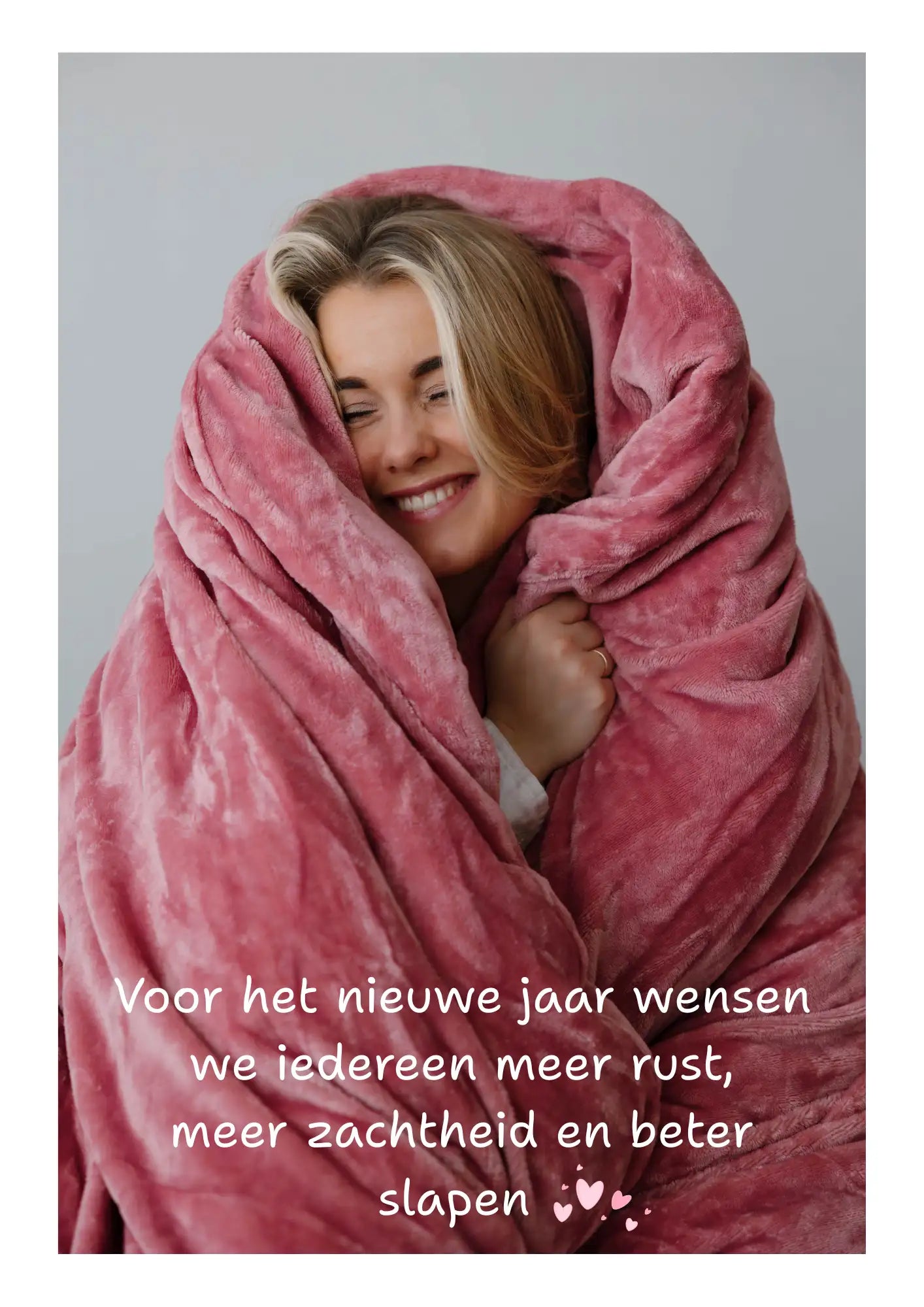 Een pluizige, zachte roze deken die warm om een glimlachende vrouw gewikkeld is.