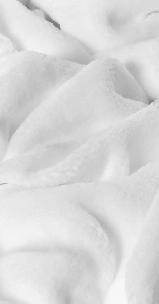 Close-up van witte velvet stof van een kussen, met een fluweelachtige, zachte textuur. De stof heeft een luxe uitstraling en subtiele glans, wat het kussen een elegante en comfortabele uitstraling geeft. foto: stof knusse wit.
